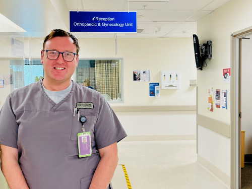 AnthonyJenkins in his Student Nurse uniform standing in the Rotorua Hospital Orthopaedic and Gynaecological Unit